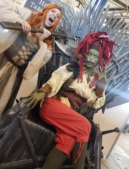 Personnages costumés de spectacle de rue, dont une gobeline aux dreadlocks rouges
